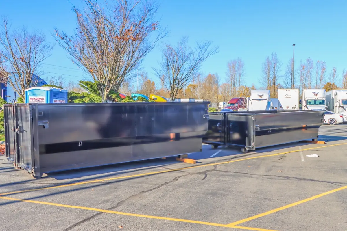 Professional dumpster rental service with roll-off container on residential driveway in Penn Hills